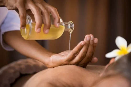 Massageöl wird in die Hand gegossen